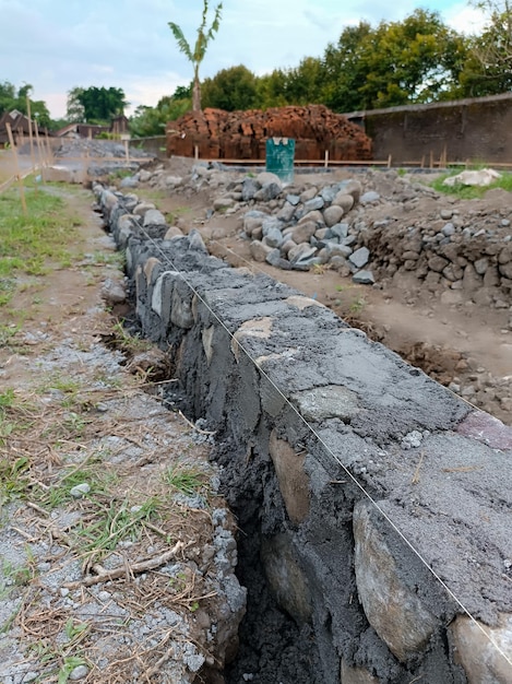 Uma parede de pedra está sendo construída em um campo.