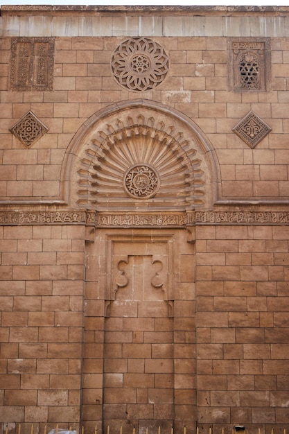 Uma parede de tijolos com um arco decorativo acima dela