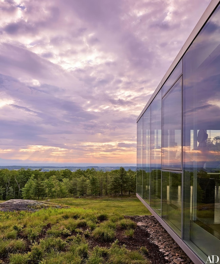 Foto uma parede de vidro de um edifício tem uma vista das montanhas e árvores