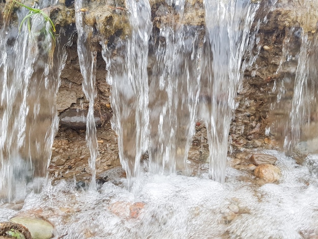 Uma pequena cachoeira Água corrente corrói o solo