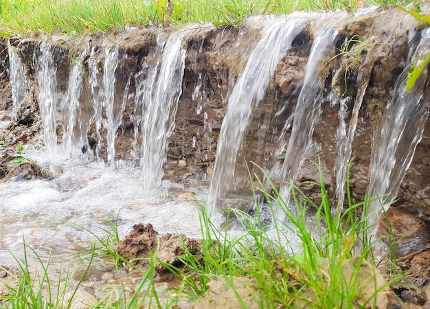 Uma pequena cachoeira Água corrente corrói o solo