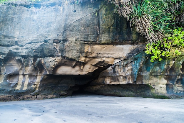 Foto uma pequena caverna na rocha acima da praia