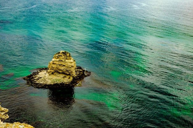 Uma pequena ilha rochosa no meio do mar.