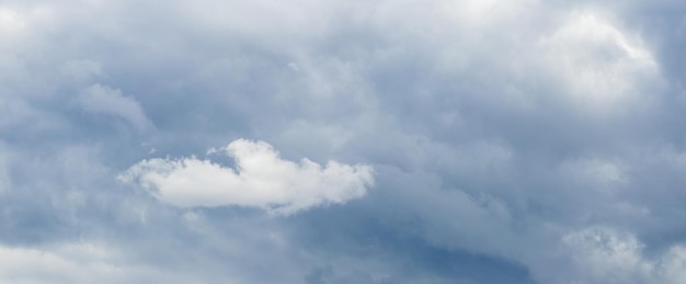 Uma pequena nuvem branca em um céu escuro e tempestuoso