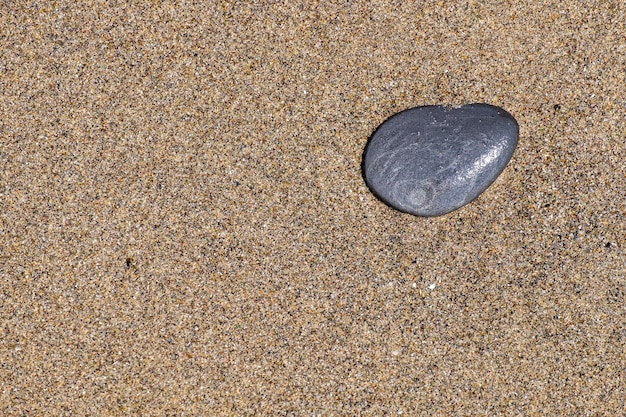 Uma pequena pedra arredondada pela erosão da areia e das ondas