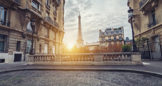 Uma pequena rua em paris com vista para a torre eiffel ao pôr do sol. ideal para layouts de sites e revistas