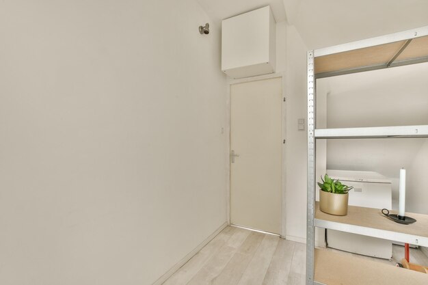 Foto uma pequena sala com uma parede branca e um armário