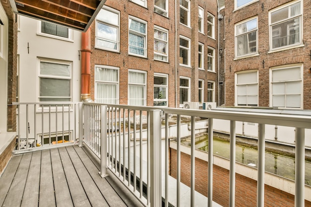 Uma pequena varanda estreita com uma cerca metálica e vista para os edifícios residenciais monolíticos diretamente em frente