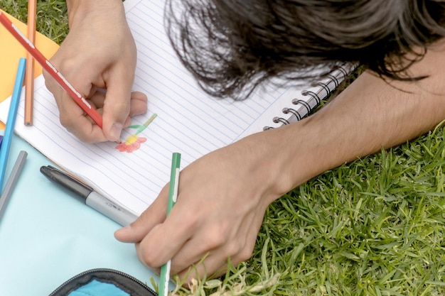 Uma pessoa a desenhar uma flor num caderno