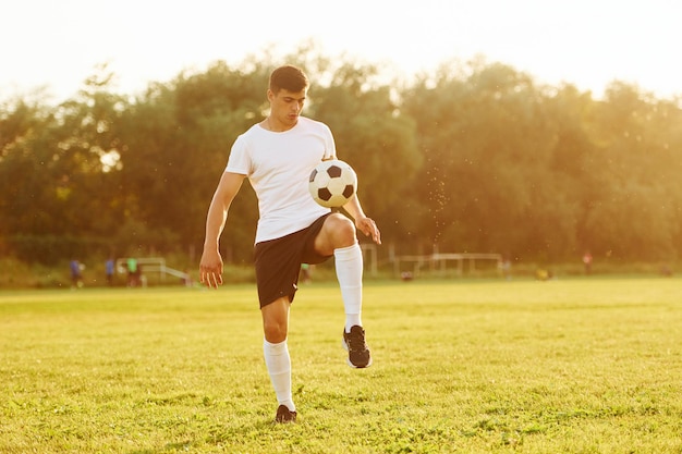 Uma pessoa apenas Jovem jogador de futebol tem treinamento no campo esportivo