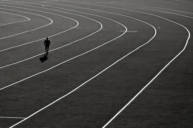 Uma pessoa caminhando em uma pista em uma cena cativante em preto e branco