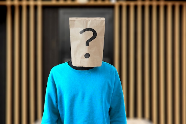 Uma pessoa com um saco de papel na cabeça com ponto de interrogação, símbolo de sinal de problema
