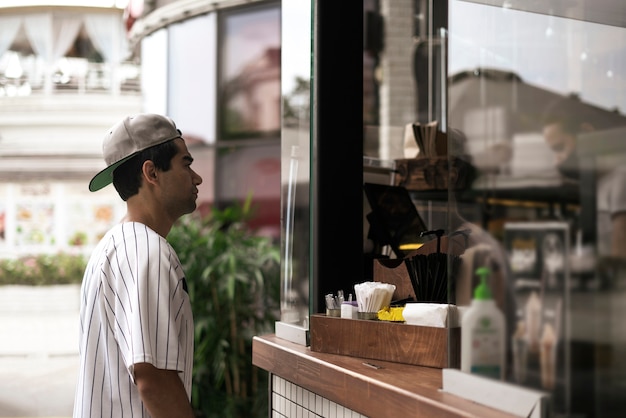 Uma pessoa comprando comida e café em um café de rua da cidade