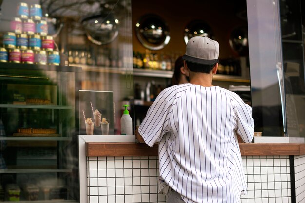 Uma pessoa comprando comida e café em um café de rua da cidade