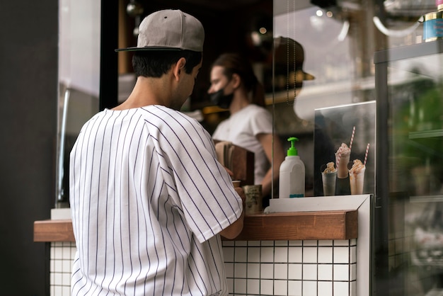 Uma pessoa comprando comida e café em um café de rua da cidade