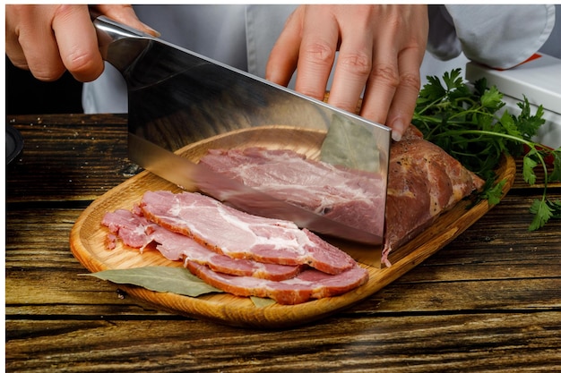 Uma pessoa cortando bacon em uma tábua