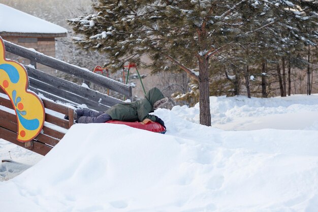 Uma pessoa deitada em uma prancha de snowboard na neve