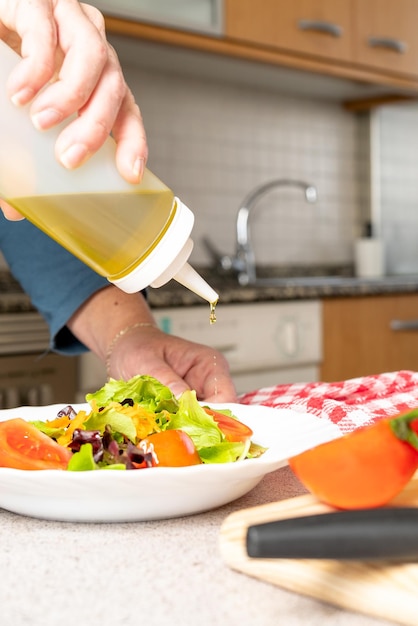 Uma pessoa derramando azeite em uma salada