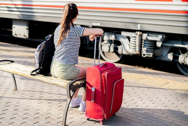 Uma pessoa do sexo feminino sentada na estação de trem esperando a viagem