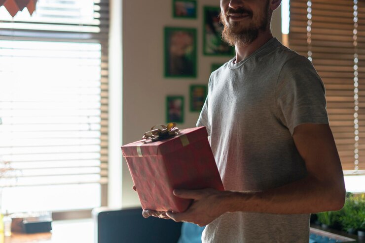 Foto uma pessoa do sexo masculino segurando uma caixa de presente vermelha na véspera de natal