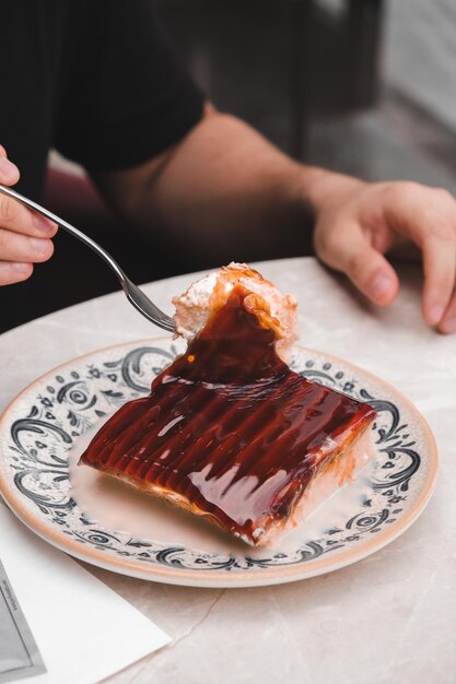 Foto uma pessoa está comendo um pedaço de bolo com um garfo