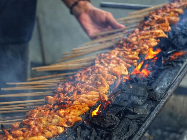 uma pessoa está cozinhando comida em uma grelha enquanto a comida está sendo cozida.