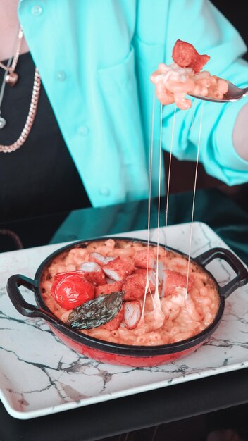 uma pessoa está derramando comida em uma panela com uma colher