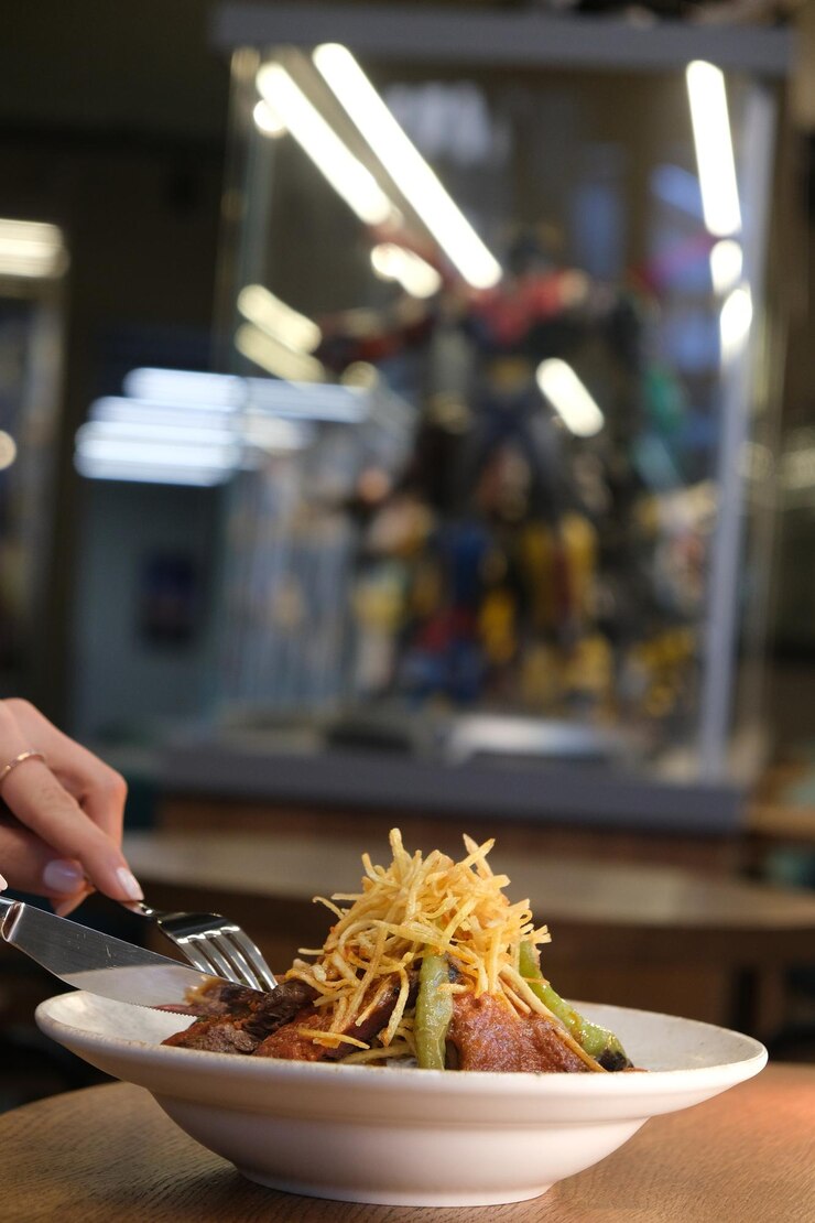 Foto uma pessoa está segurando um prato com comida e uma faca com um garfo e uma faca