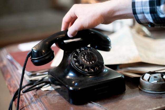 Uma pessoa fazendo uma ligação telefônica usando um antigo telefone rotativo vintage