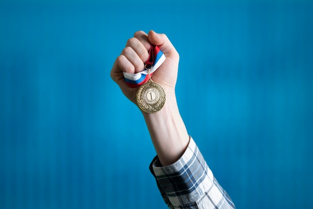 Foto uma pessoa levantou a mão ganhando o primeiro lugar, segurou a medalha de ouro