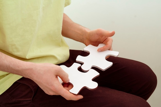 Uma pessoa segurando e conectando pizzles quebra-cabeças, resolvendo o problema