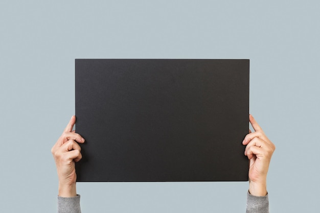 Uma pessoa segurando um quadro-negro com a palavra arte.