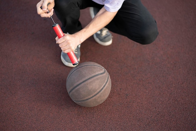 Uma pessoa segurando uma bomba manual vermelha e uma bola de basquete