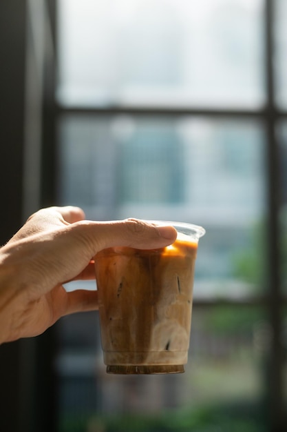 Foto uma pessoa segurando uma xícara de café gelado