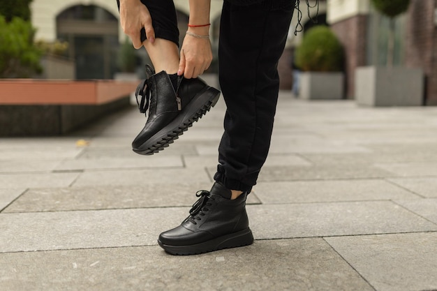 Uma pessoa usando sapatos pretos e um par de sapatos pretos.