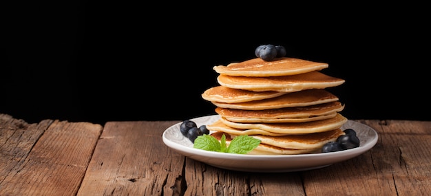 Uma pilha de deliciosas panquecas com mel.