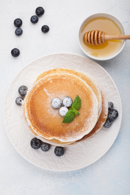 Uma pilha de deliciosas panquecas com mel.