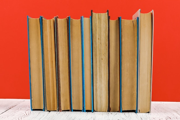Uma pilha de livros em uma mesa branca sobre um fundo vermelho