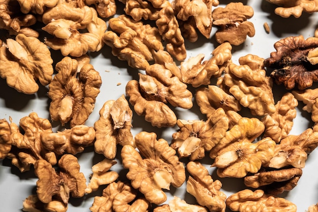 Foto uma pilha de nozes já descascadas em uma mesa branca para uma dieta