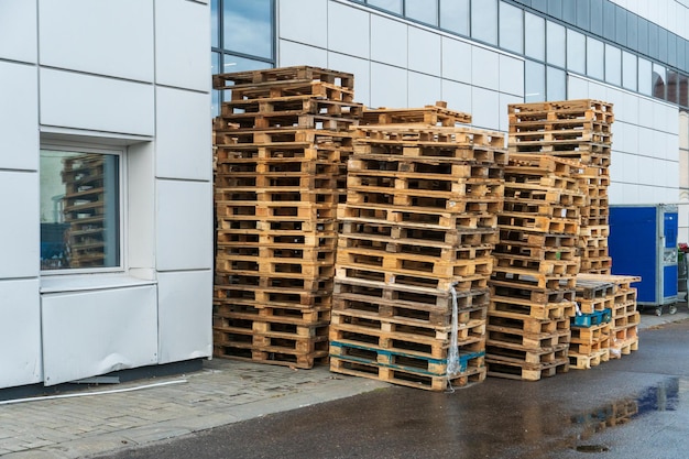 Uma pilha de paletes de madeira em um armazém interno Uma área de armazenamento de paletes ao ar livre sob o telhado ao lado da loja Pilhas de paletes de carga Eurotype em uma instalação de reciclagem de resíduos