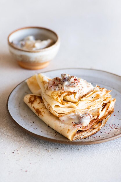 Uma pilha de panquecas com creme e canela por cima.