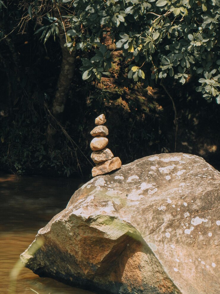 uma pilha de pedras senta-se no topo de uma rocha
