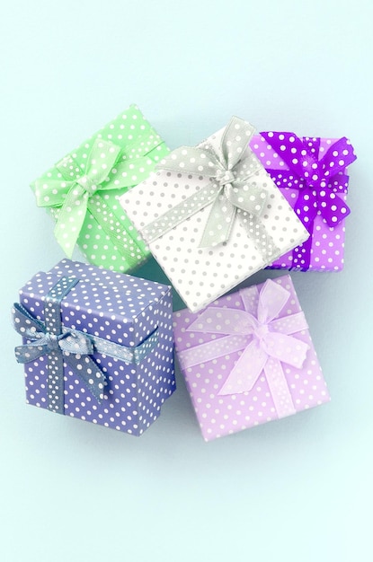 Uma pilha de pequenas caixas de presentes coloridas com fitas encontra-se em um fundo violeta Minimalismo plano lay top view