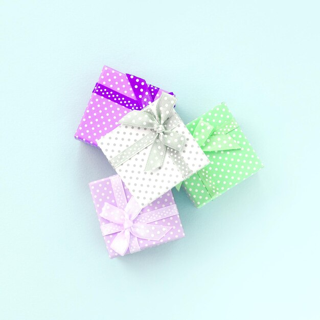Uma pilha de pequenas caixas de presentes coloridas com fitas fica em um fundo violeta minimalismo colocou plano