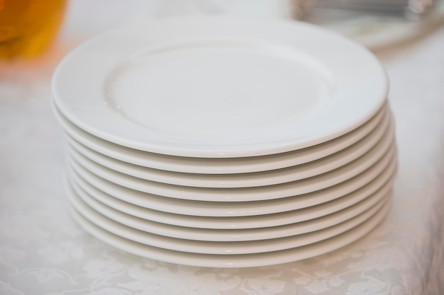 Uma pilha de pratos brancos na mesa