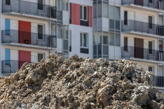 Uma pilha de solo sujo no contexto da fachada de um prédio de apartamentos