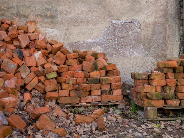 Uma pilha de tijolos vermelhos velhos um material de construção esquecido uma pilha de pedras uma construção inacabada conceito de tijolo vermelho