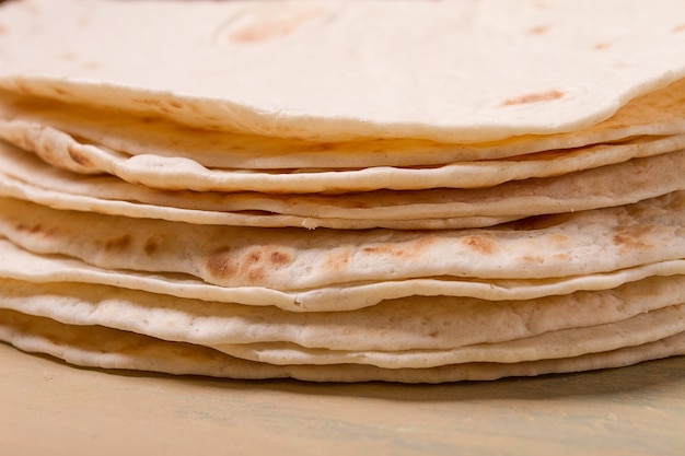 Uma pilha de tortilhas mexicanas em uma mesa cinza vista de cima sem pessoas