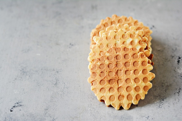 Uma pilha de waffles belgas holandeses com caramelo salgado em um fundo cinza