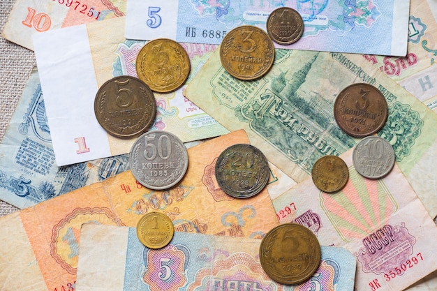 Uma pilha do papel moeda e de moedas soviéticas dispersou na tabela.